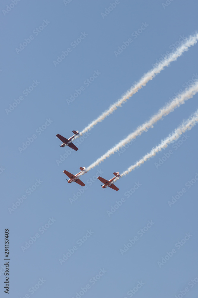 Three colorful jets flying in the sky and performing a show leaving smoke marks Three colorful jets flying in the sky and performing a show leaving smoke marks