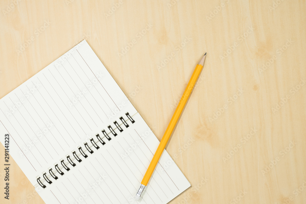 yellow pencil with notebook on wooden desk,flat lay. Top view. yellow pencil with notebook on wooden desk,flat lay. Top view.