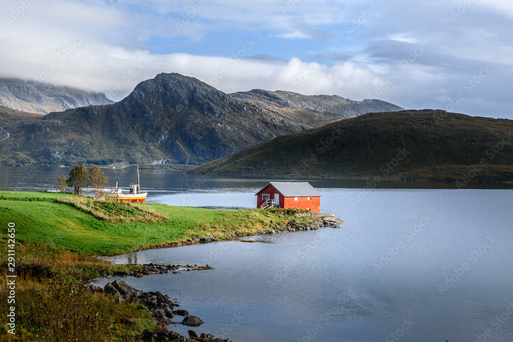Lonely traditional nordic red wooden house in the beautiful landscape of lofoten islands Norway. Concept of peaceful living