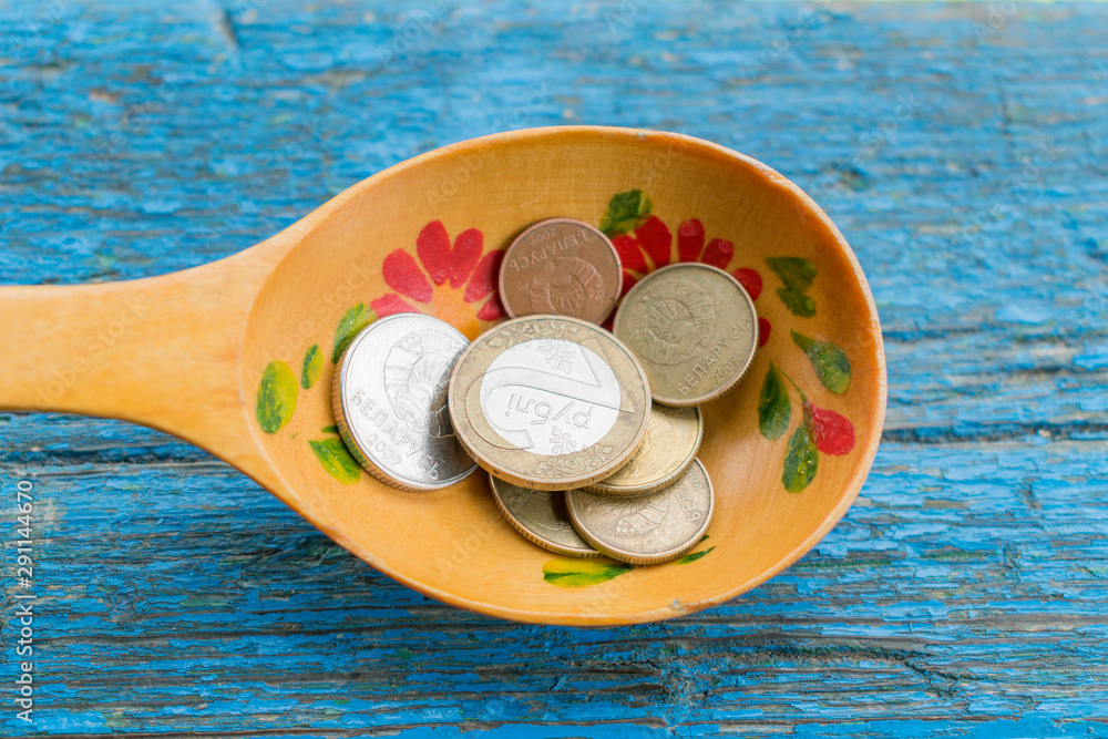 Wooden spoon with coins on the edge of the wooden table blue Stock Photo |  Adobe Stock