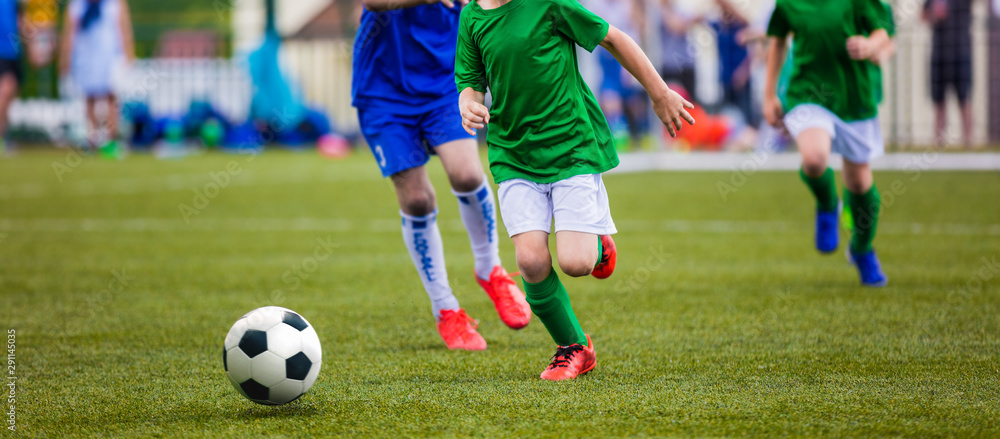 Boys Kicking Soccer Ball. Children Soccer Team on Game. Kids Running with Ball on Football Pitch. Young Soccer Players in Action Boys Kicking Soccer Ball. Children Soccer Team on Game. Kids Running with Ball on Football Pitch. Young Soccer Players in Action