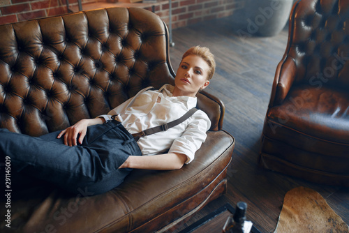 Woman with cigar lying on couch, retro fashion