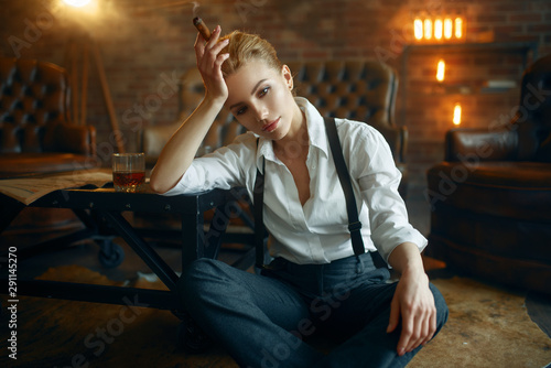 Woman sitting on the floor with whiskey and cigar