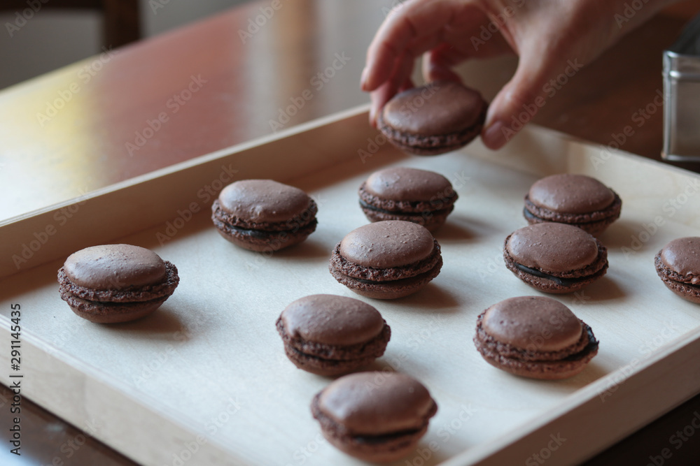 chocolate macarons arranged on a wooden tray chocolate macarons arranged on a wooden tray