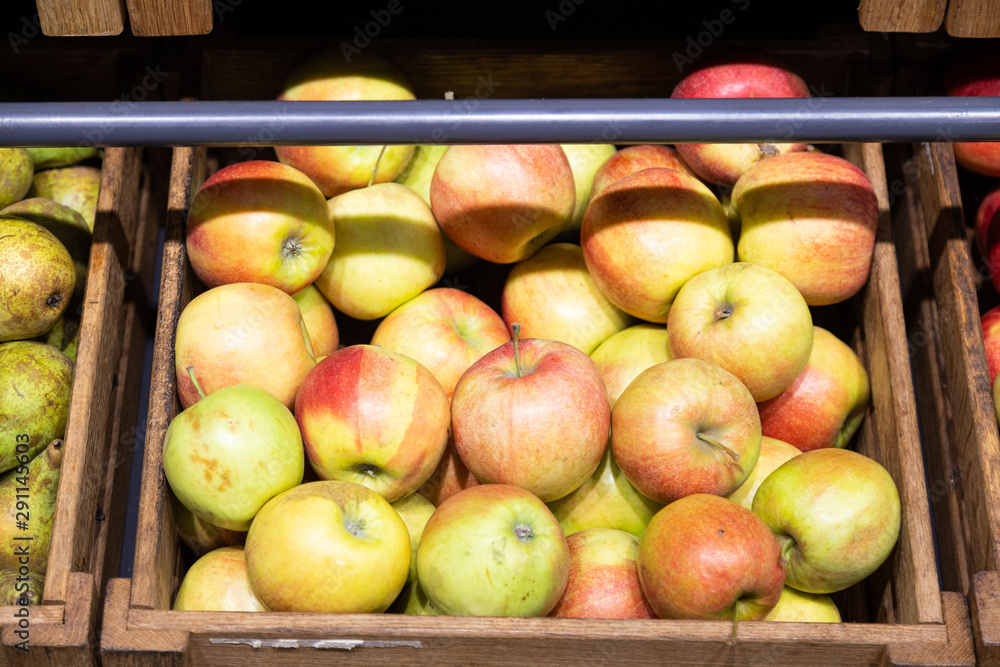 Wooden lug box with green and red apples on counter Wooden lug box with green and red apples on counter
