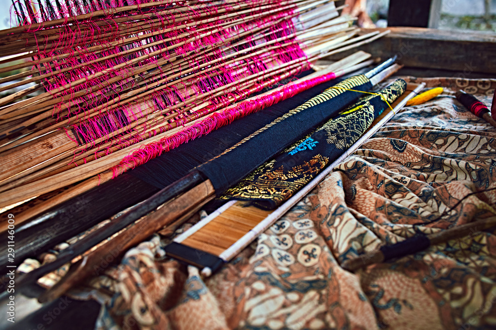 Weaving fabric. Weaving and manufacturing of handmade carpets closeup. Hand made on a wooden loom manufacture of thread and fabric