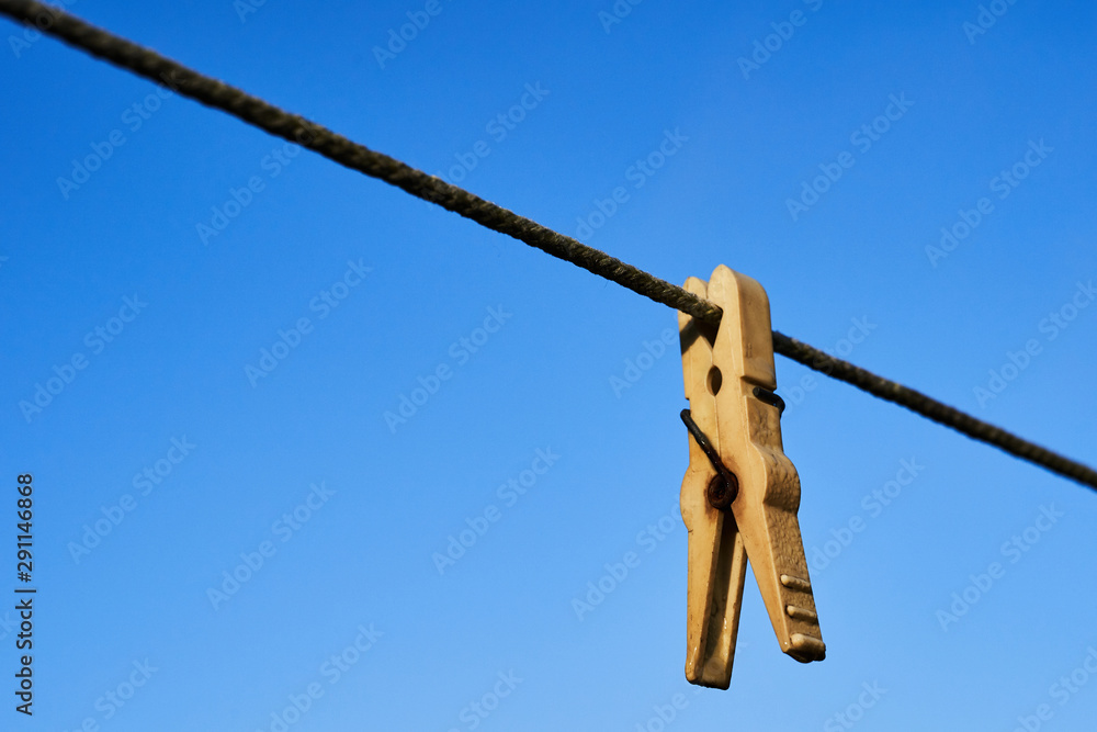 Clothespin on a rope against the blue sky Clothespin on a rope against the blue sky