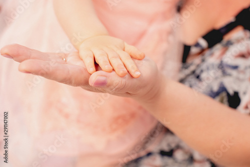 hand of a one-year-old child on the hand of a grandmother photo