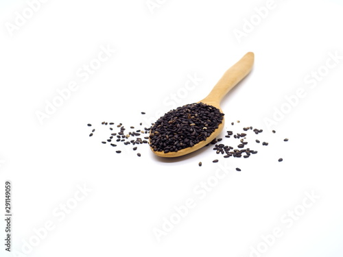Black sesame in wooden spoon isolated on white background. 