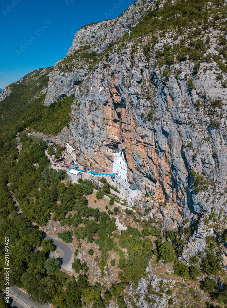 Aerial view of The Monastery of Ostrog, Serbian Orthodox Church situated against a vertical background, high up in the large rock of Ostroška Greda, Montenegro. Dedicated to Saint Basil of Ostrog 