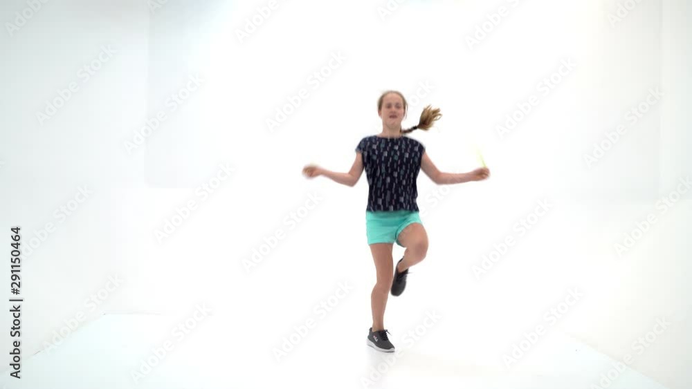 A girl gymnast performs exercises with a skipping rope. A girl gymnast performs exercises with a skipping rope.