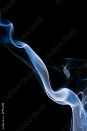 Delicate streak of smoke on black background, delightful aroma