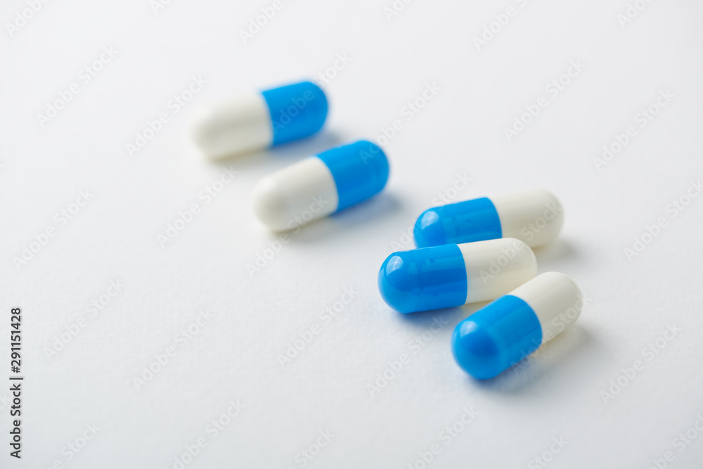 Creatine capsules. Sports supplements on bright paper background. Close up. Copy space. Creatine capsules. Sports supplements on bright paper background. Close up. Copy space.