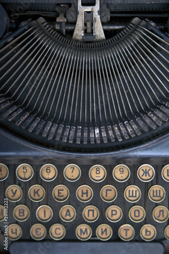 Details of an old retro typewriter, vintage style, dusty surfaces. Black vintage typewriter closeup mechanism.