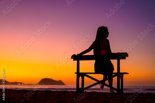 Zarautz, Gipuzkoa / Spain »; September 2019: Lifestyle, a girl sitting on a chair in summer sunset looking to the right