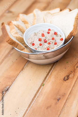 Tuna dip with bread and paprika on a wooden table