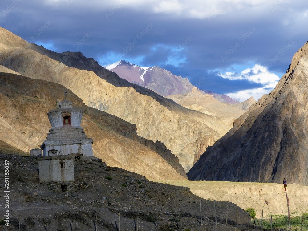 Antica stupa al tramonto davanti ad un paesaggio montagnoso nel Ladakh in India. 