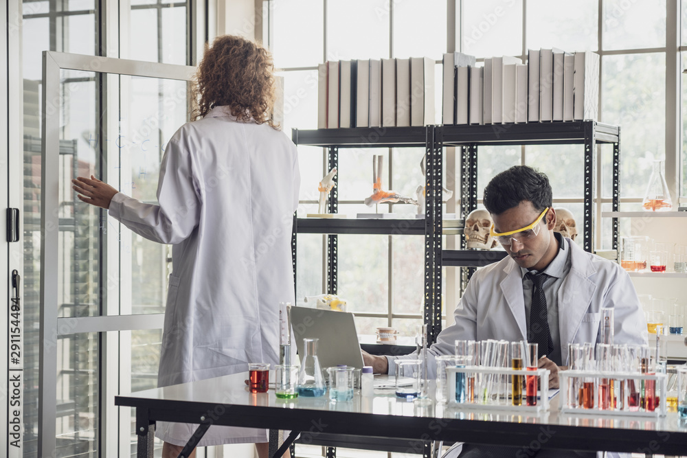 Team of Medical Research Scientist Conducts Experiments in Laboratory with Microscope, Test Tubes, Micropipette and other equipment. Team of Medical Research Scientist Conducts Experiments in Laboratory with Microscope, Test Tubes, Micropipette and other equipment.