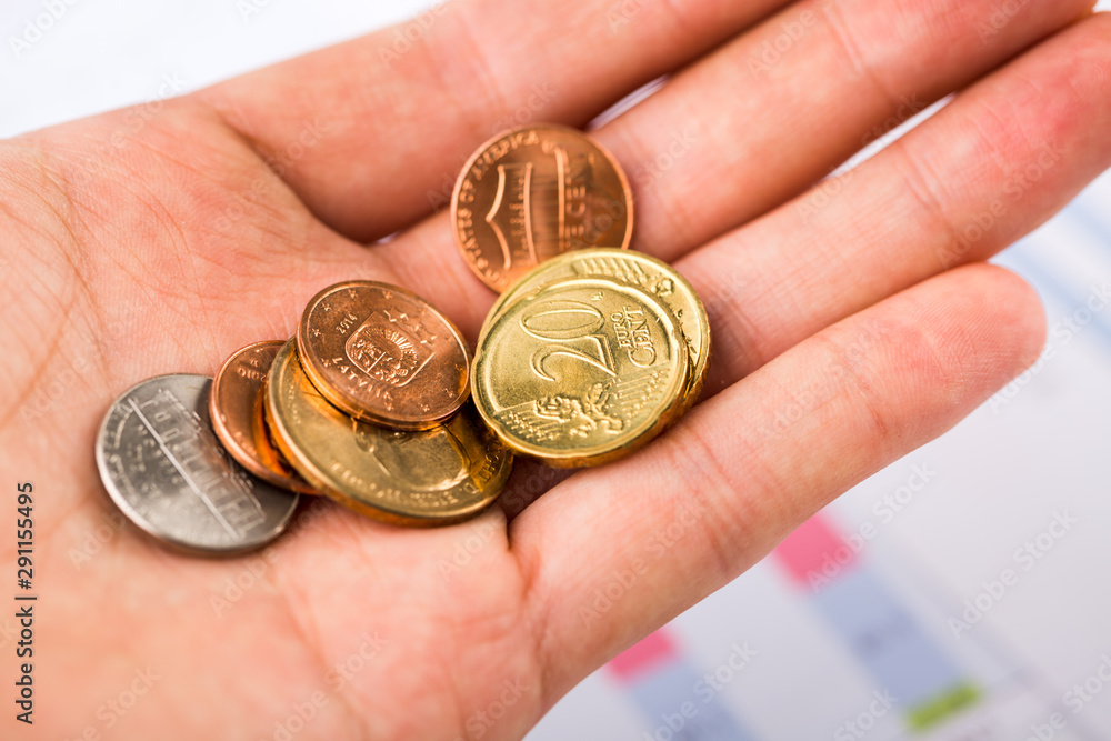 Money coins in hand with business chart background, euro coins, dollar coins Money coins in hand with business chart background, euro coins, dollar coins