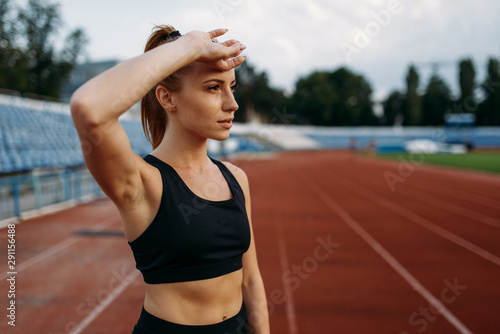 Tired female runner, training on stadium