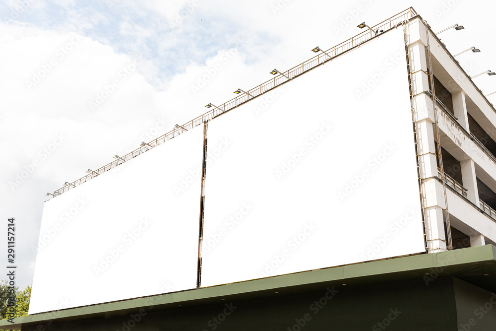 Two empty white boards on building facade, diagonal view. Two empty white boards on building facade, diagonal view.