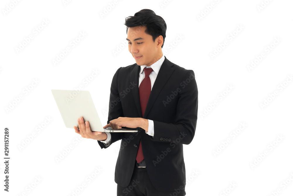 Young handsome business man with his notebook ,cheking email and other information standing over isolated white background,