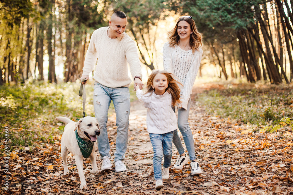 Happy beautiful family with dog labrador is having fun together walking the in park. Happy beautiful family with dog labrador is having fun together walking the in park.