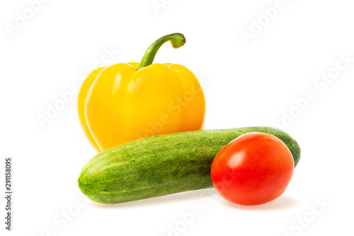 Closeup image of vegetables festive three colors group. Red tomato, green cucumber and yellow pepper isolated at white background.