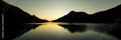 sunset on a clear calm day over loch leven near kinlochleven in the argyll region of scotland during autumn showing calm waters and golden hues