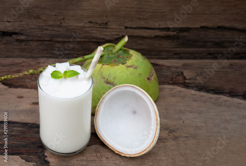 Coconut smoothies white fruit juice milkshake blend beverage healthy high protein the taste yummy In glass drink episode morning on a wooden background from top view.