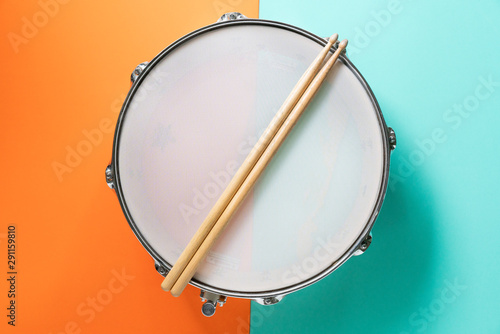Fotografia Drum stick on color table background, top view, music concept