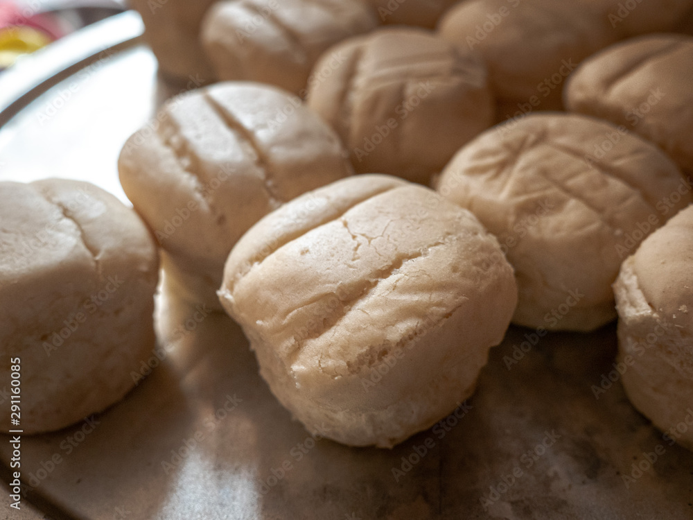A closeup photograph of a pile of brown and serve oven baked dinner rolls or buns on a metal serving tray. A closeup photograph of a pile of brown and serve oven baked dinner rolls or buns on a metal serving tray.