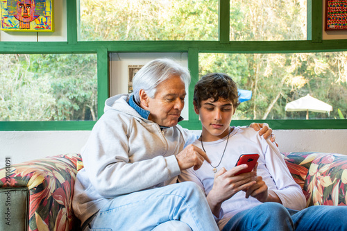 Father and teenage son with mobile phone fun social network