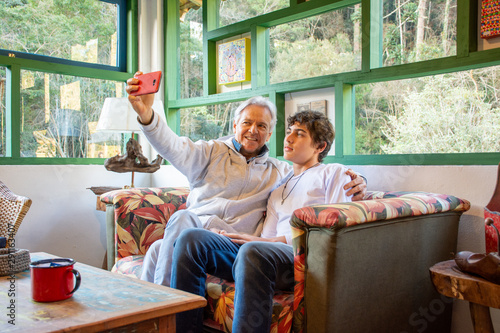 Father and teenage son with mobile phone fun social network