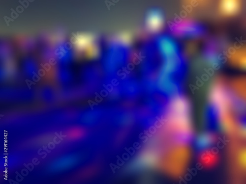 Abstract silhouettes of dancing people with strobe lights and multicolored highlights with bokeh and blur effect, disco with social dancing outdoors