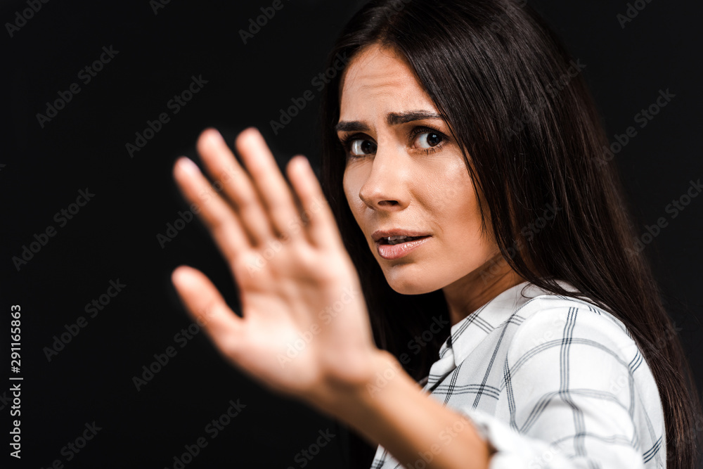 selective focus of upset woman gesturing while looking at camera isolated on black selective focus of upset woman gesturing while looking at camera isolated on black