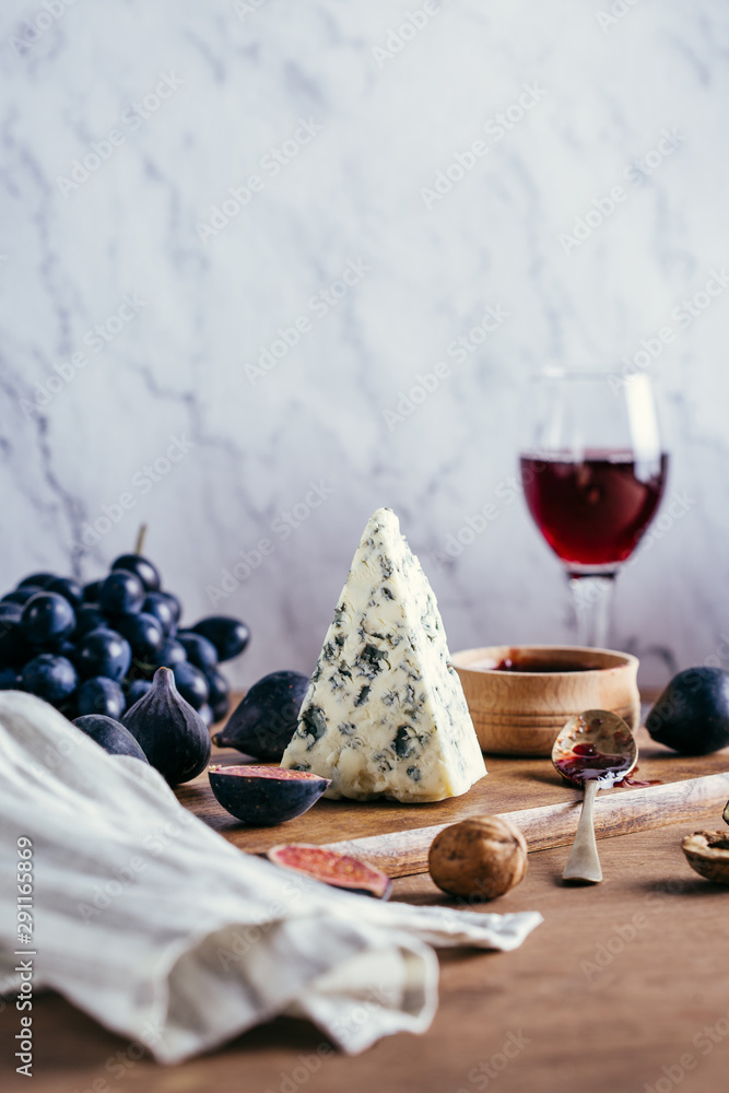 Dorblu, blue cheese with grapes and figs on a wooden board