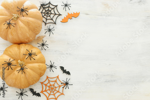 holidays Halloween image. pumpkin, bats and spiders over wooden white table. top view, flat lay