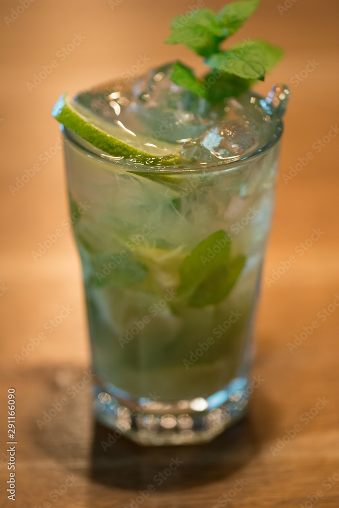 Refreshing mint cocktail mojito with rum and lime, cold drink or beverage with ice on white wooden background, top view Refreshing mint cocktail mojito with rum and lime, cold drink or beverage with ice on white wooden background, top view
