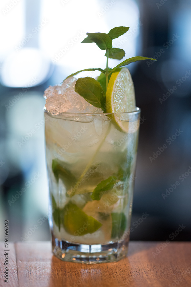 Refreshing mint cocktail mojito with rum and lime, cold drink or beverage with ice on white wooden background, top view Refreshing mint cocktail mojito with rum and lime, cold drink or beverage with ice on white wooden background, top view