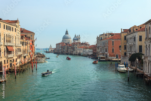 View of Canal Grande. Various boats float by a fine architectural complex of embankments.