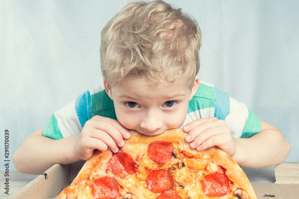 boy eating pepperoni pizza. kids love pizza. pizza party Stock Photo