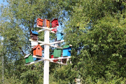 on a white pole set a few houses for birdhouses