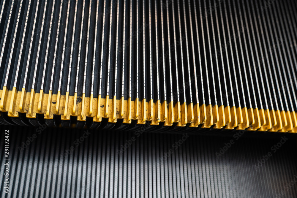 Close up metal escalator stairs with yellow plastic rubber anti-slip stair nosing. Close up metal escalator stairs with yellow plastic rubber anti-slip stair nosing.