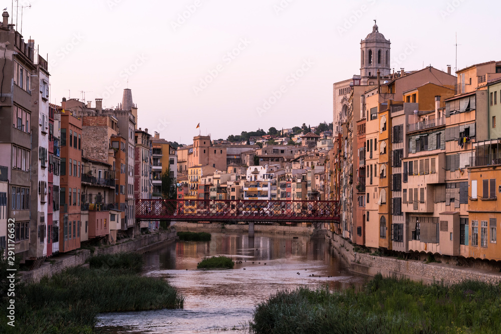 Obraz premium Colorful yellow and orange houses reflected in water river Onyar, in Girona, Catalonia, Spain.