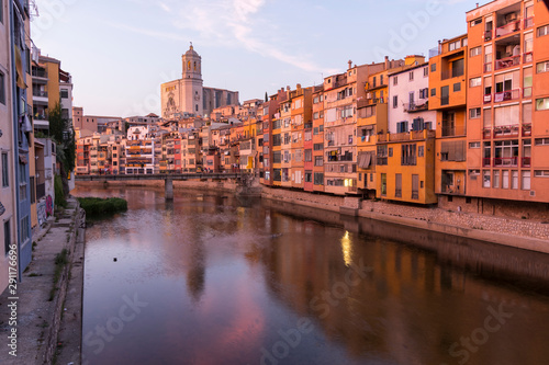 Colorful yellow and orange houses reflected in water river Onyar, in Girona, Catalonia, Spain. photo