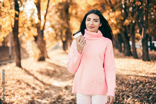 Beautiful woman drink coffee and walking in the park.