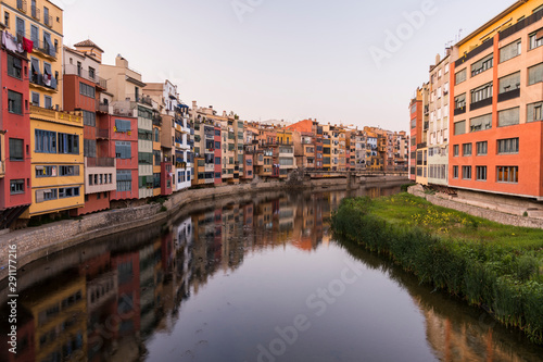 Colorful yellow and orange houses reflected in water river Onyar  in Girona  Catalonia  Spain.