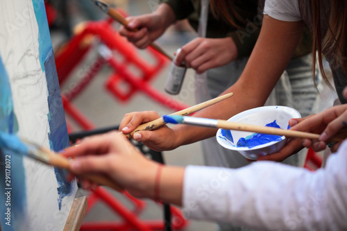 Artist paints a picture of oil paint brush in hand close up.Selective focus