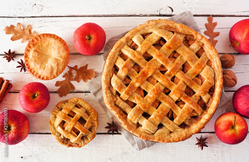 Homemade autumn apple pies, top view table scene with a white wood background